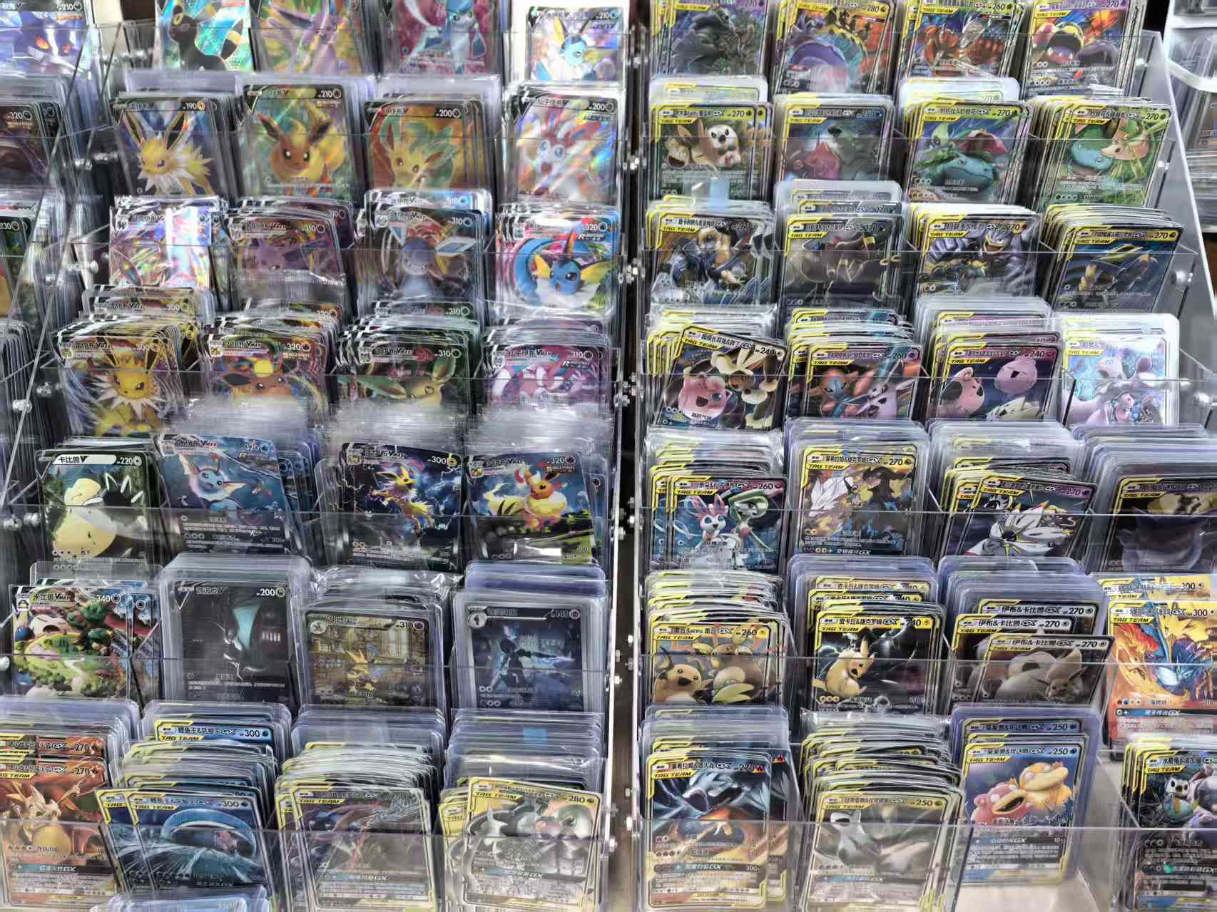 Cartas Pokémon reales en chino simplificado organizadas en bandejas transparentes